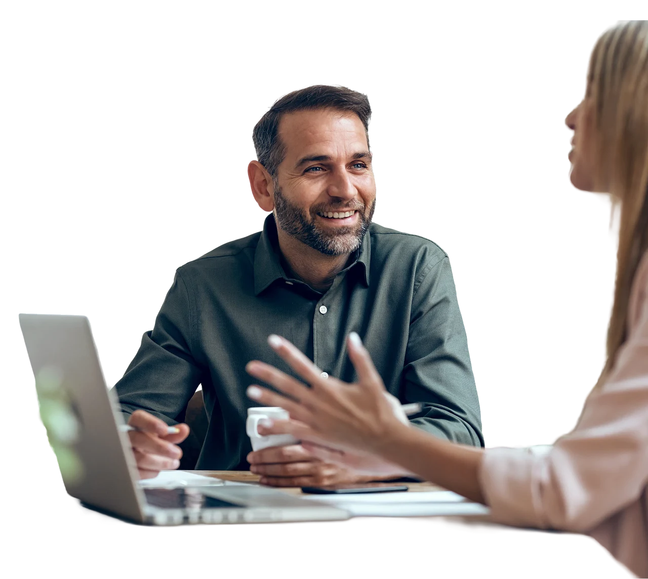 An advisor in conversation with a client across a table with a laptop